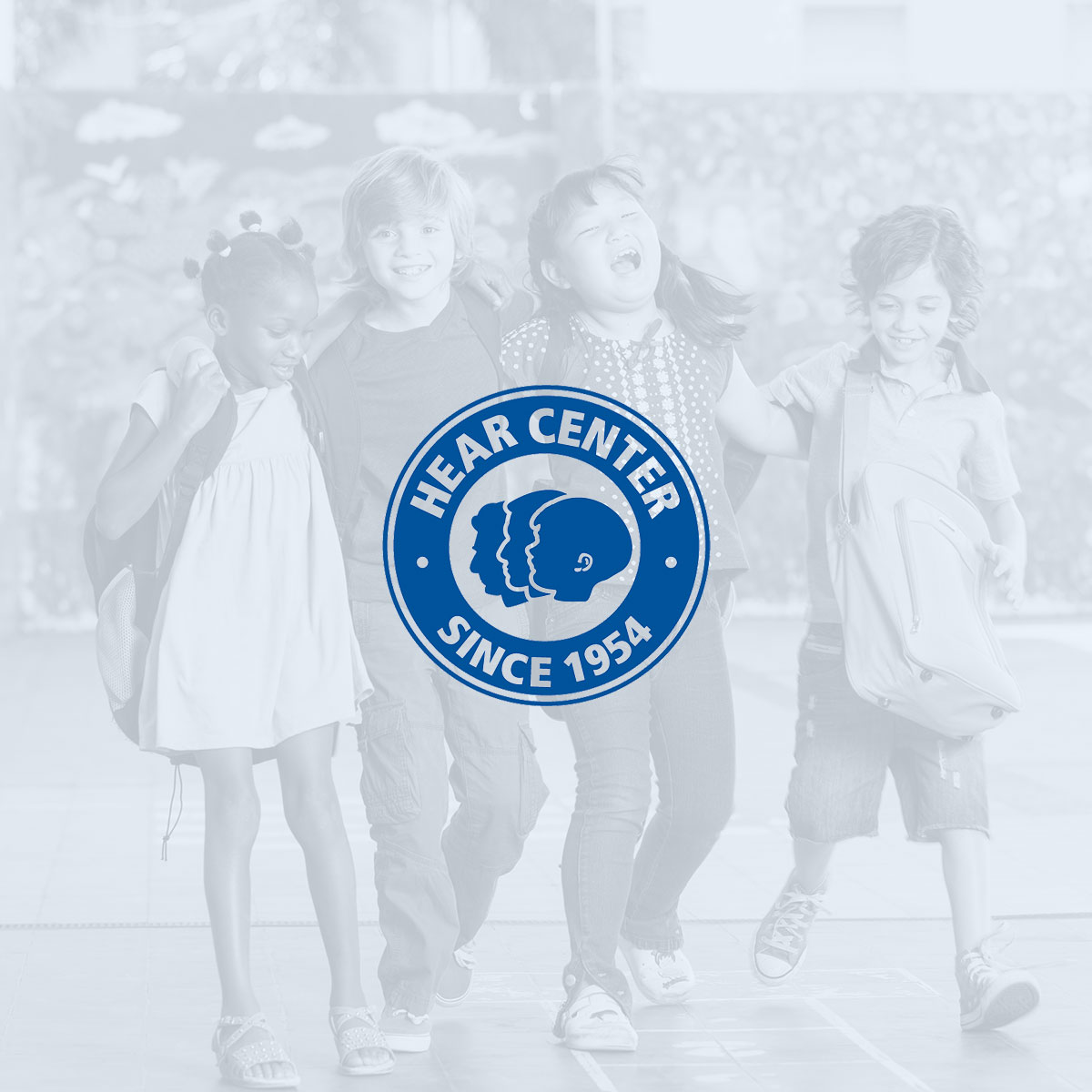 HEAR Center Image - Diverse kids walking in a row together with HEAR Center Logo