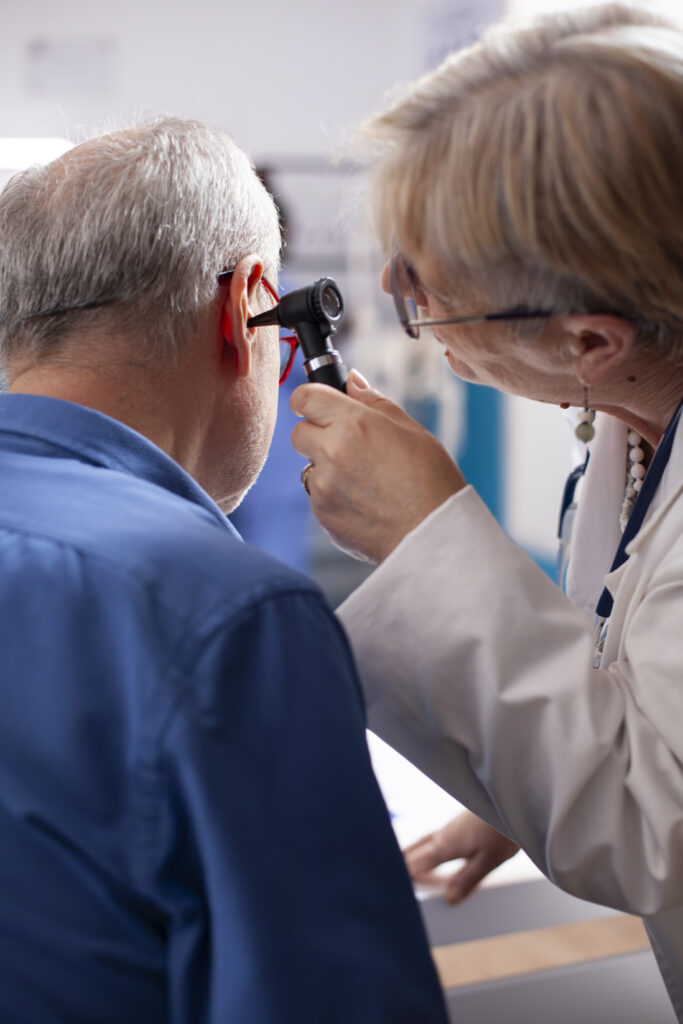 Physician Inspects Ear Of Elderly Man